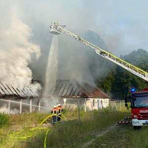 26398314-feuerwehreinsatz-an-einem-langgestreckten-gebaeude-auf-einer-wiese-vom-korb-der-drehl...jpg